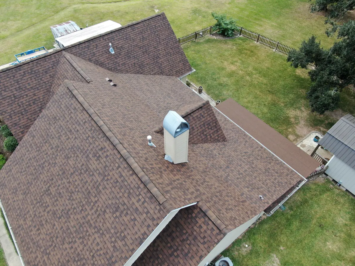 Aerial view of a home with a new roof beside a pool.