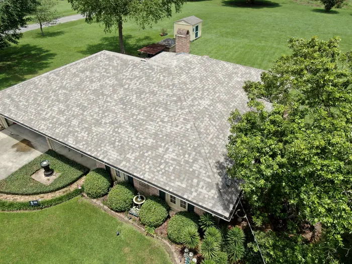 Aerial view of a completed shingle roof on a long ranch home.